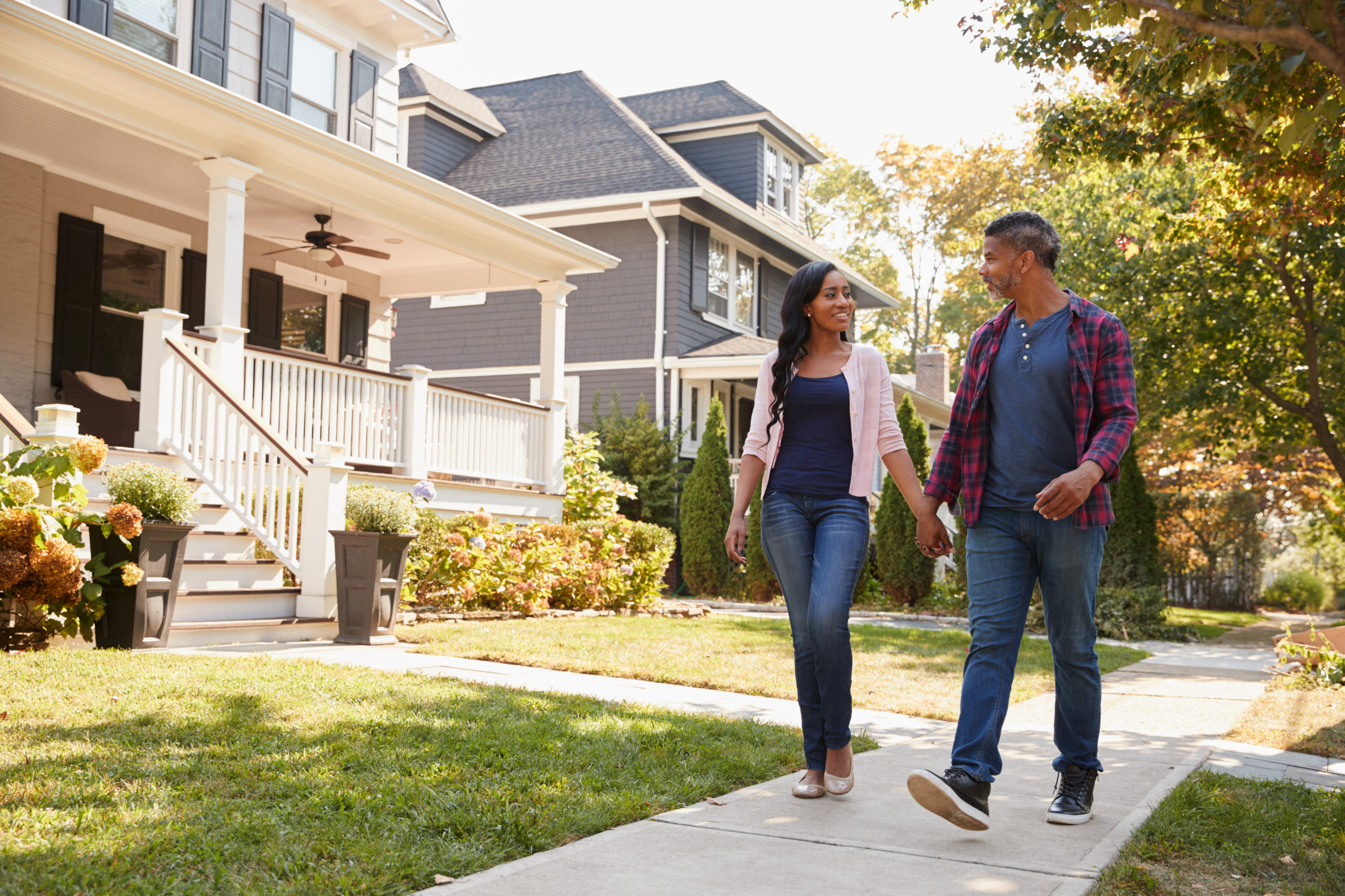 Couple,Walking,Along,Suburban,Street,Holding,Hands
